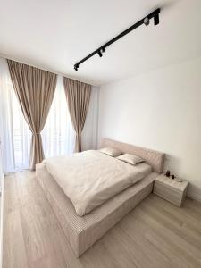 蒂米什瓦拉Milo Residence的白色卧室设有大床和大窗户