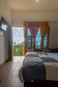 een slaapkamer met een bed en een groot raam bij Nature's View Kandwari in Pālampur