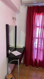 a desk with a mirror next to a red curtain at Rooms Lemonakia Beach in Kokkari