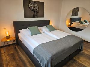 a bedroom with a large bed with a mirror at MV Römerlodge mit einmaligem Moselpanoramablick in Treis-Karden