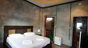 une chambre avec un grand lit avec des draps blancs dans l'établissement Pilton Resort, à Ban Huai Yang