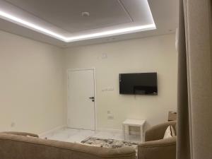 a living room with a couch and a flat screen tv at شقق الضباب 2 in Al Baha +4 photos