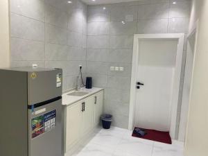 a small kitchen with a refrigerator and a sink at شقق الضباب 2 in Al Baha