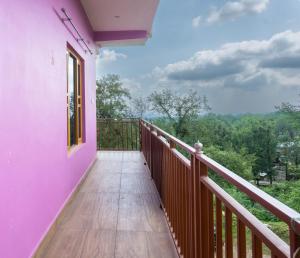 een balkon van een roze huis met uitzicht bij Nature's View Kandwari in Pālampur