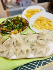 un tavolo con piatti di ravioli e patatine fritte di Guest House a Sevan Altre 23 foto