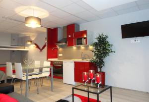 uma cozinha e sala de jantar com armários vermelhos e uma mesa em Equinaturi em Santo Tirso