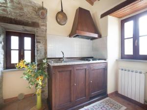 a kitchen with wooden cabinets and a sink at Farmhouse in Apecchio with Swimming Pool, Terrace, Garden in Apecchio