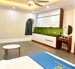 a kitchen with a sink and a desk in a room at Royal Louis Hotel in Dai Mo