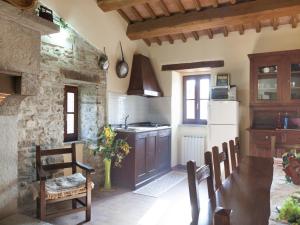 a kitchen with a table and a sink and a stove at Farmhouse in Apecchio with Swimming Pool, Terrace, Garden in Apecchio