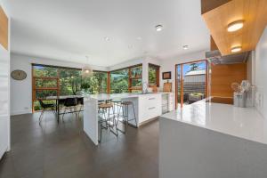 a kitchen with white cabinets and a table with chairs at Huon Valley House in Ranelagh