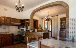 a kitchen with a wooden table and an archway at Villa Tre Laghi Vista Paradiso Piscina acqua salata provincia Perugia conf Toscana 22 posti in Castiglione del Lago