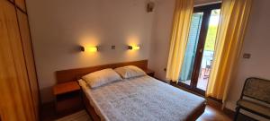 a bedroom with a bed with two pillows on it at Apartments BEVANDA in Šimuni
