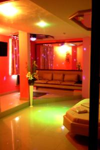 uma sala de estar com um sofá e luzes verdes em Lips Motel (Adult Only) no Rio de Janeiro