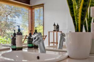 un lavandino in bagno con due rubinetti e uno specchio di Huon Valley House a Ranelagh Altre 39 foto