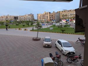 two cars parked in a parking lot next to a street at Bawany Apartment in Dargai