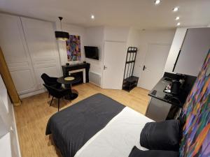 a bedroom with a bed and a table and a couch at 1 - Confortable studio RDC Châlons-en-Champagne in Chalons en Champagne
