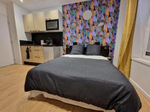 a bedroom with a large bed and a kitchen at 1 - Confortable studio RDC Châlons-en-Champagne in Chalons en Champagne