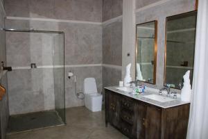 a bathroom with a shower and a sink and a toilet at Kuriftu Entoto Adventure Park in Addis Ababa +13 photos