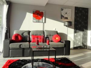 a living room with a gray couch with red pillows at Equinaturi in Santo Tirso +31 photos