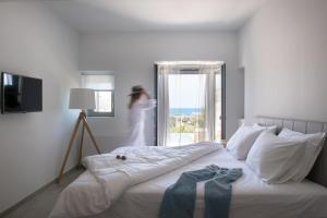 a woman is standing in a bedroom with a bed at Villa Hermione in Agios Nikolaos