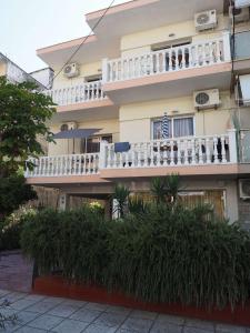 a building with white balconies and plants in front of it at Villa Anastasia Olympic Beach in Olympiaki Akti