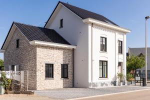 a white house with a black roof at Luna Logies in Lanaken