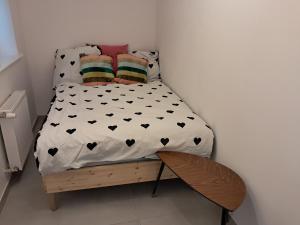 a small bedroom with a bed with black hearts at Kawalerka ul Wojska Polskiego in Skorka