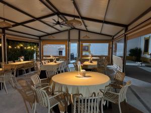 a restaurant with tables and chairs and windows at Complejo Rural Los Molinos in Salorino
