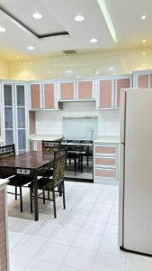 a large kitchen with a table and a refrigerator at شاليهات ووحدات فندقية وشقق مفروشة بالباحة - العقيق in Al ‘Aqīq