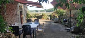 einen Tisch, Stühle und einen Regenschirm auf einer Terrasse in der Unterkunft Villa rivière sur le Golfe in Pluneret