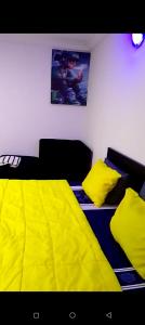 two beds in a room with yellow sheets and pillows at Peace in Lekki