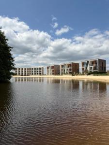 eine Reihe von Apartmentgebäuden neben einem Wasserkörper in der Unterkunft Luxapartments - Lake View Apartment 202 in Penati Golf Resort in Šajdíkove Humence