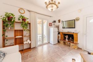 a living room with a fireplace and a white refrigerator at Villa-Toula in Roda