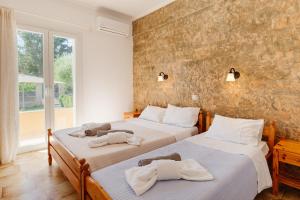 a bedroom with two beds with towels on them at Villa-Toula in Roda +67 photos