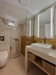 a bathroom with a sink and a toilet and a mirror at Aurora Suite in Xanthi