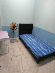 Cama en habitación con ventilador en Rent Room, en Ipoh