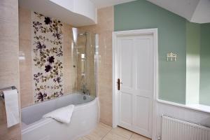 a bathroom with a white tub and a shower at Brownes Farm House- relisted for 2022 in Ballymacart Bridge