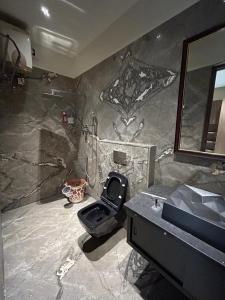 La salle de bains est pourvue de toilettes noires et d'un lavabo. dans l'établissement Home Stay, à Jāmb
