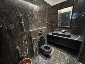 La salle de bains noire est pourvue de toilettes et d'un lavabo. dans l'établissement Home Stay, à Jāmb 12 autres photos