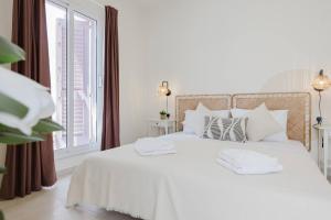 a white bed with white pillows and a window at Solea Apartment In Mellieha By Homely! in Mellieħa