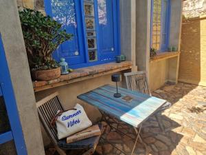 a table and chairs on a porch with a blue window at Casa Olive in San Vito