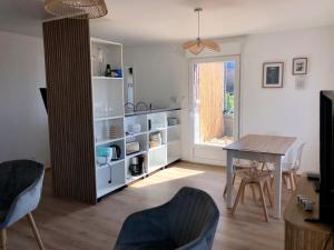 a living room with a table and a table and chairs at Appartement vue mer - 3ème étage in Ault