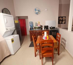 a small kitchen with a table and chairs and a refrigerator at Marissa Guest House in San Ignacio