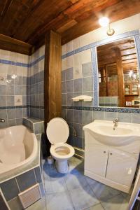 een badkamer met een toilet, een bad en een wastafel bij Antik Apartmán Levoča in Levoča