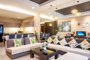 a living room with two couches and a table at Phirom3 pool villa pattaya in Jomtien Beach