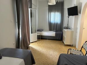 a small room with two beds and a mirror at Kamara rooms in Naousa in Naousa