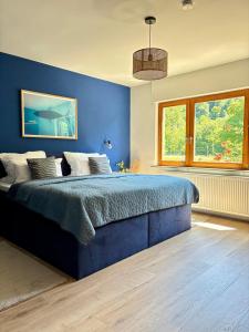 a blue bedroom with a bed and a window at Ferienwohnung direkt am Wasser in Lahnstein