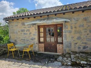 a table and chairs in front of a building at Entre Pierres et Légendes in Cajarc