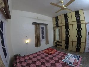 Un dormitorio con una cama y un ventilador de techo. en Nomind Vibe Art Space, en Dharamsala