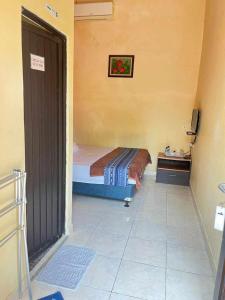a small bedroom with a bed and a television at RST NWR Pulau Tidung in Pulau Tidung-besar